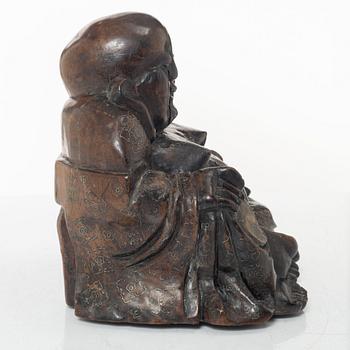 A Chinese wooden figure of Budai with silver inlays, Qing dynasty (1644-1912).