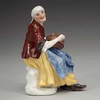 A porcelain figure of a begger playing an instrument, 1740's, presumably Meissen.