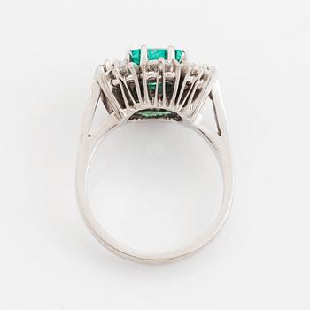 An 18K white gold ring set with a step-cut emerald.