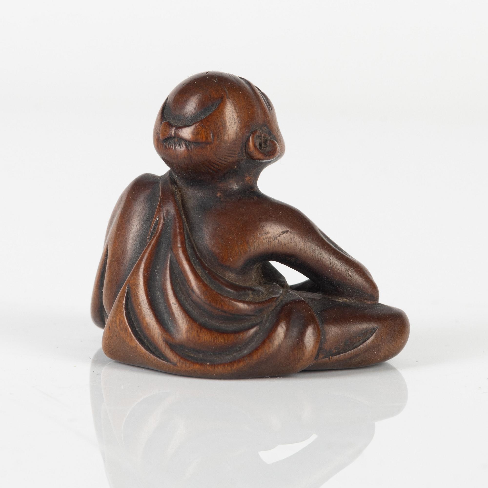 A wood netsuke of a professional sneezer, signed Gyokkō