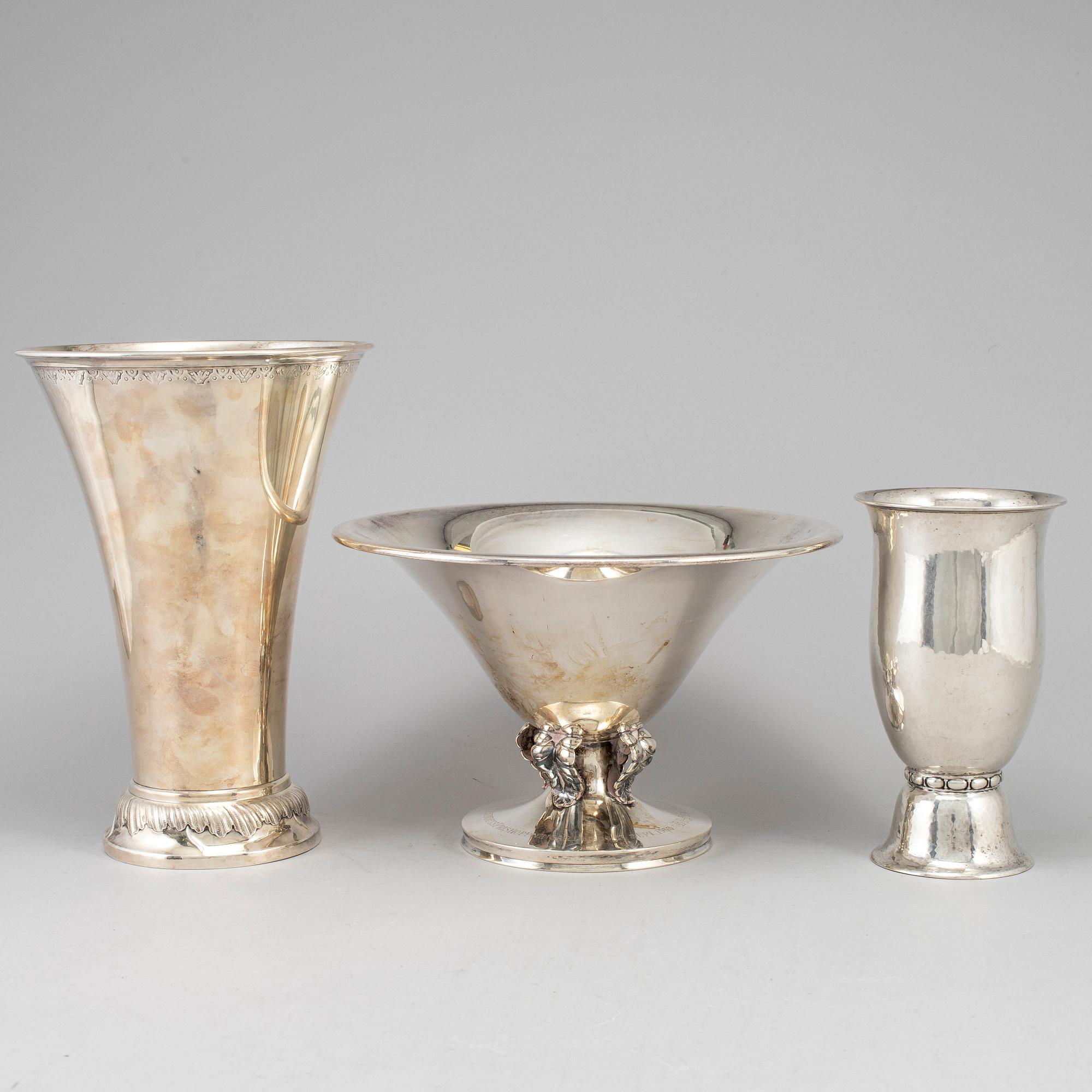 Two silver beakers and a bowl.