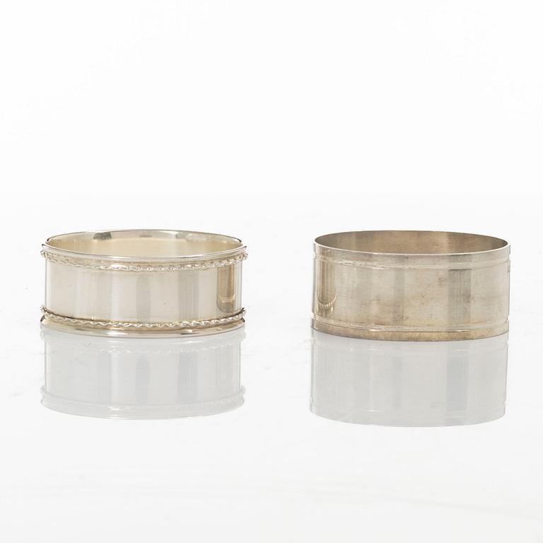 A pair of beakers, two napkin rings, and 17 pieces of cutlery, silver.