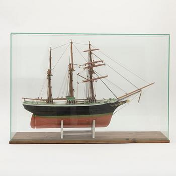 Ship model, topsail schooner, in display case, 20th century.