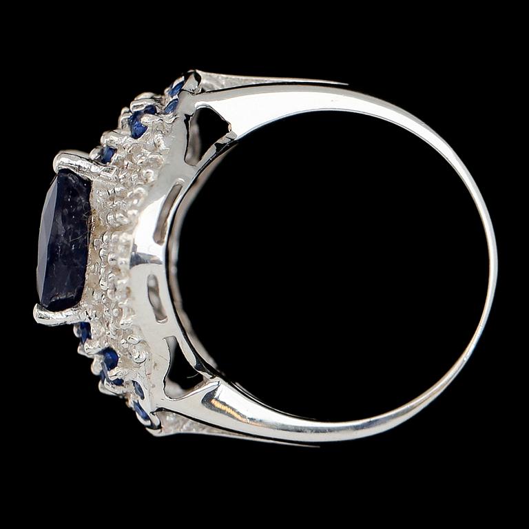 RING, sterlingsilver, oval safir ca 5.90 ct, mindre blå safirer tot ca 0.52 ct, vita safirer tot ca 0.84 ct.