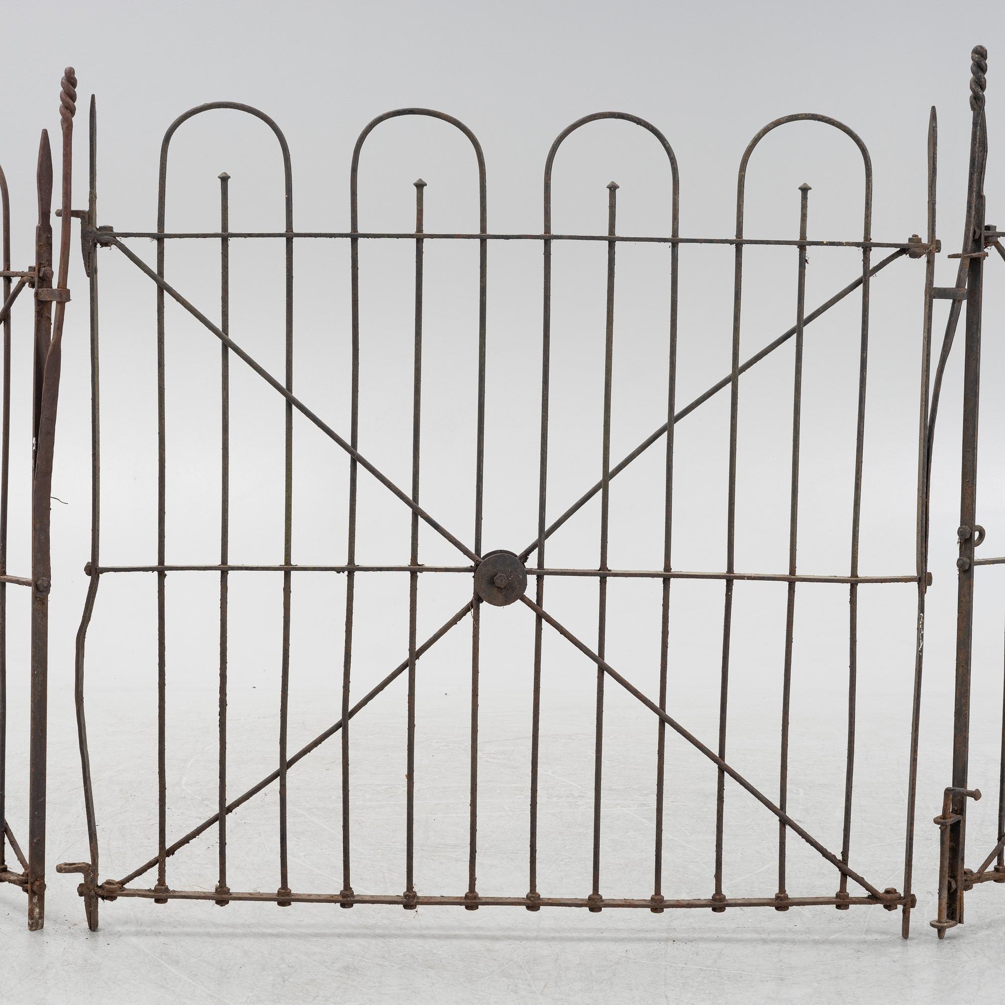 A pair of iron garden gates and a single gate from the early 20th century.