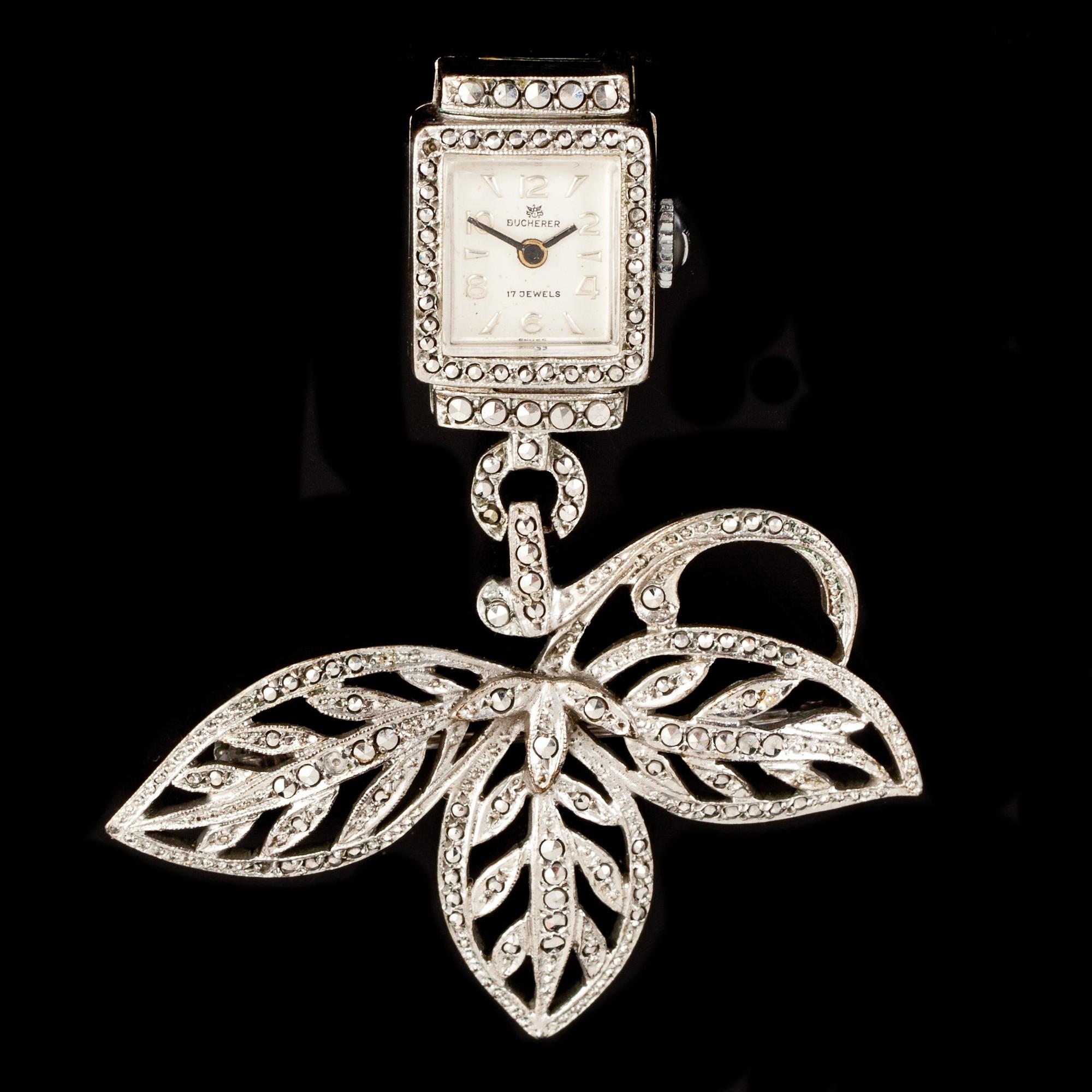 KLOCKA/BROSCH, vitmetall med markasiter. Bucherer. 1900-tal.