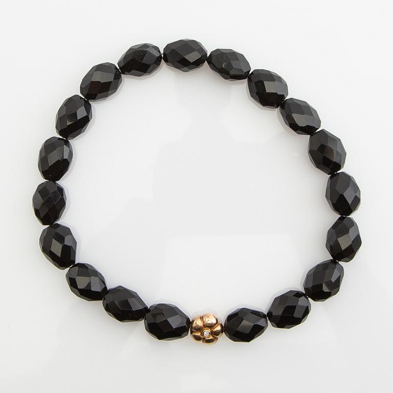 Ole Lynggaard, clasp, 18K gold with a round brilliant-cut diamond, and two necklaces.