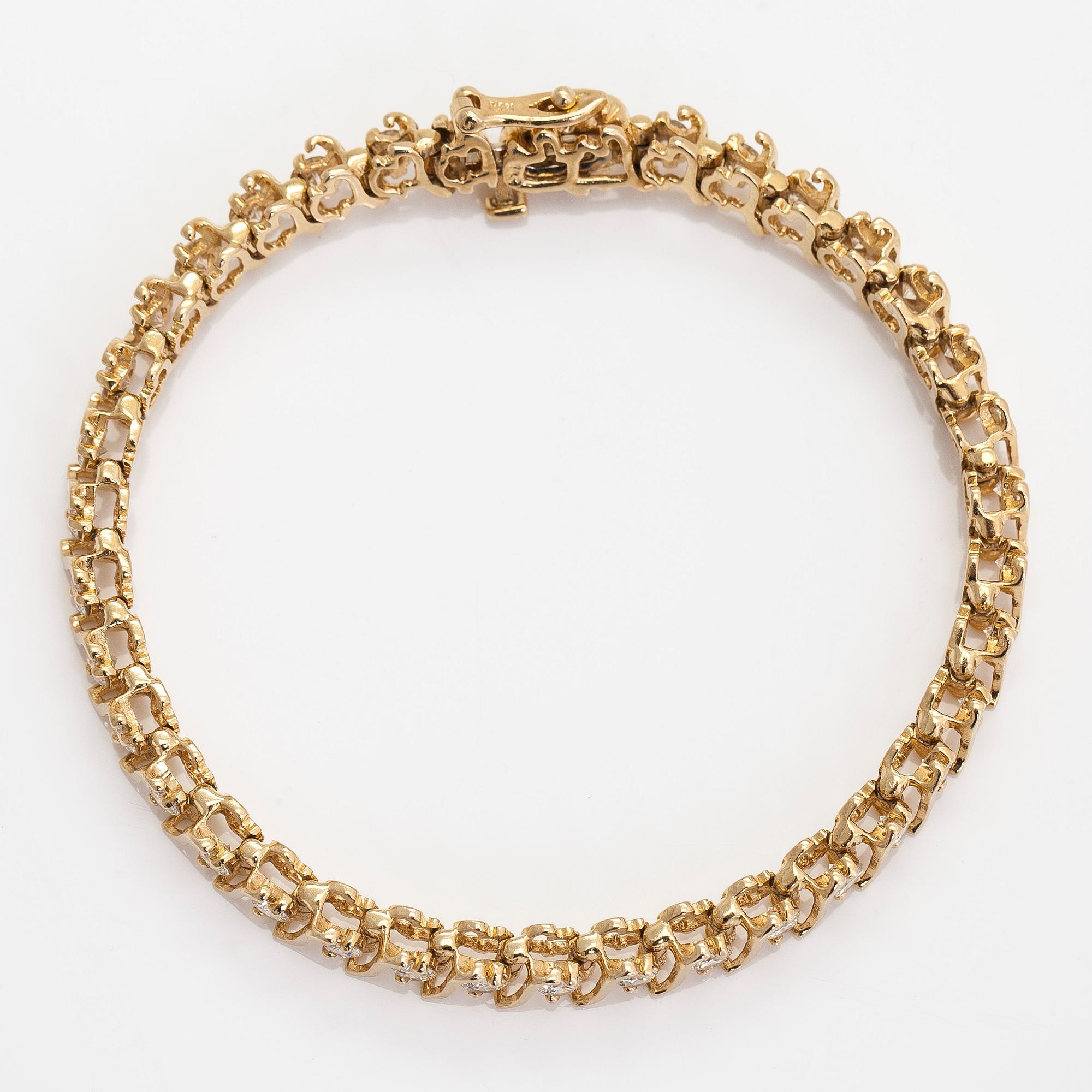 A 14K gold tennis bracelet, with brilliant-cut diamonds.