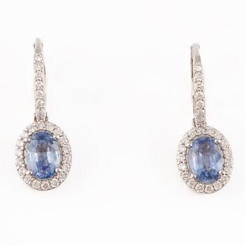 A pair of 18K gold earrings with faceted sapphires and round brilliant-cut diamonds.