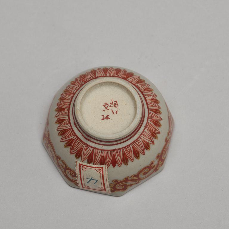 A set of two Japanese figures and a set of six cups in a wooden box, early 20th Century.