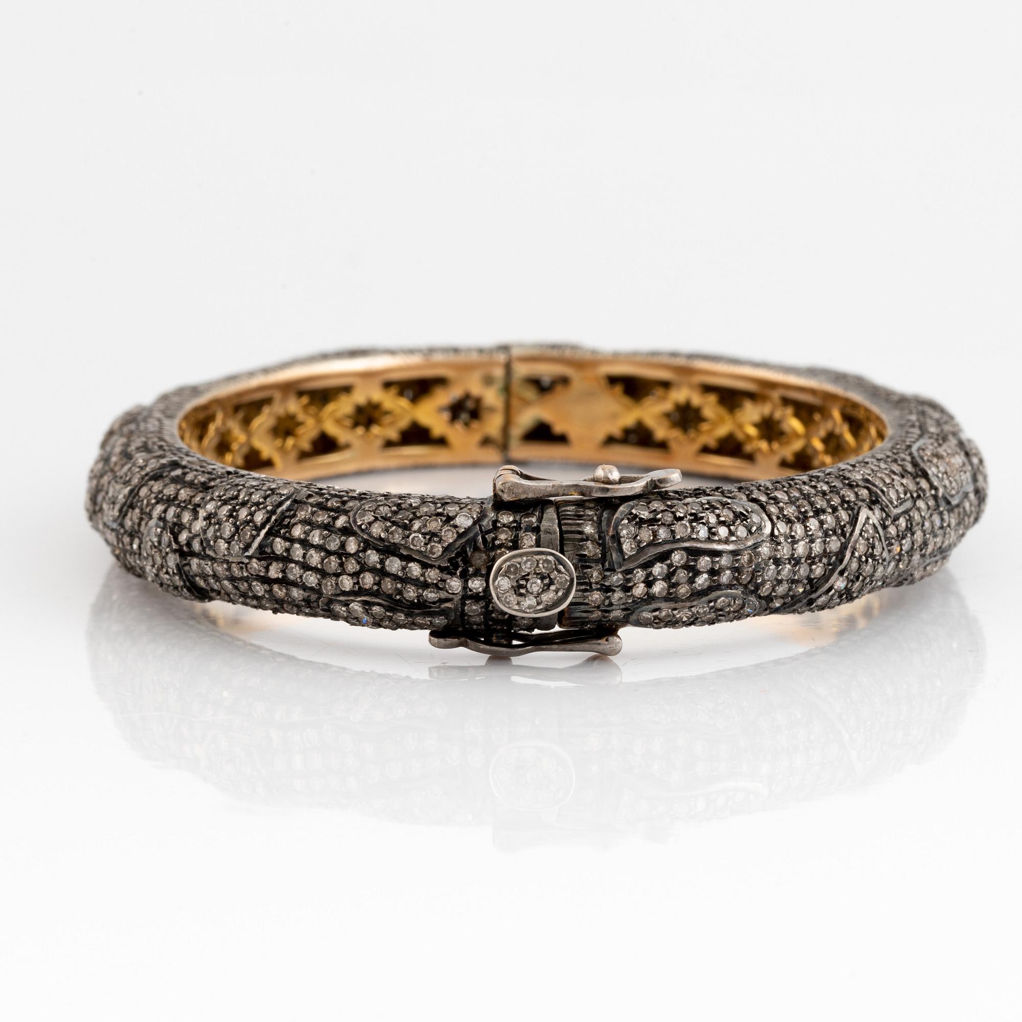 Silver and giltet gold and eight cut diamond bangle.