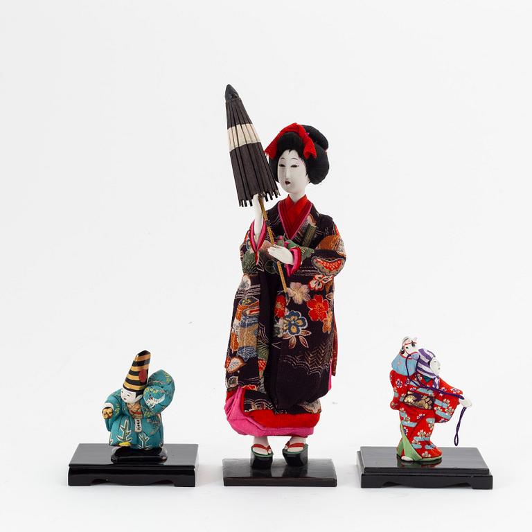 A group of Japanese dolls and lacquered miniature furniture in wooden crates, early 20th Century.