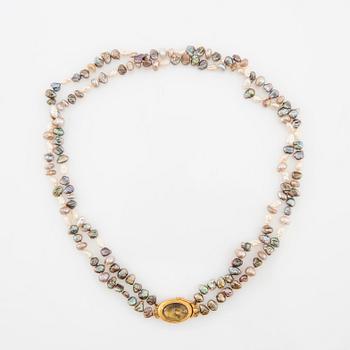 Necklace of cultured pearls with a clasp of 18K gold and cabochon-cut likely tourmaline.