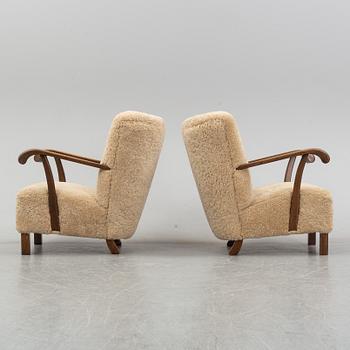 A pair of Danish lounge chairs with sheepskin upholstery.