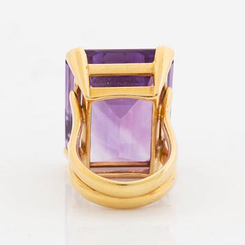 A Tina Karlsson ring in 18K gold set with a faceted amethyst.