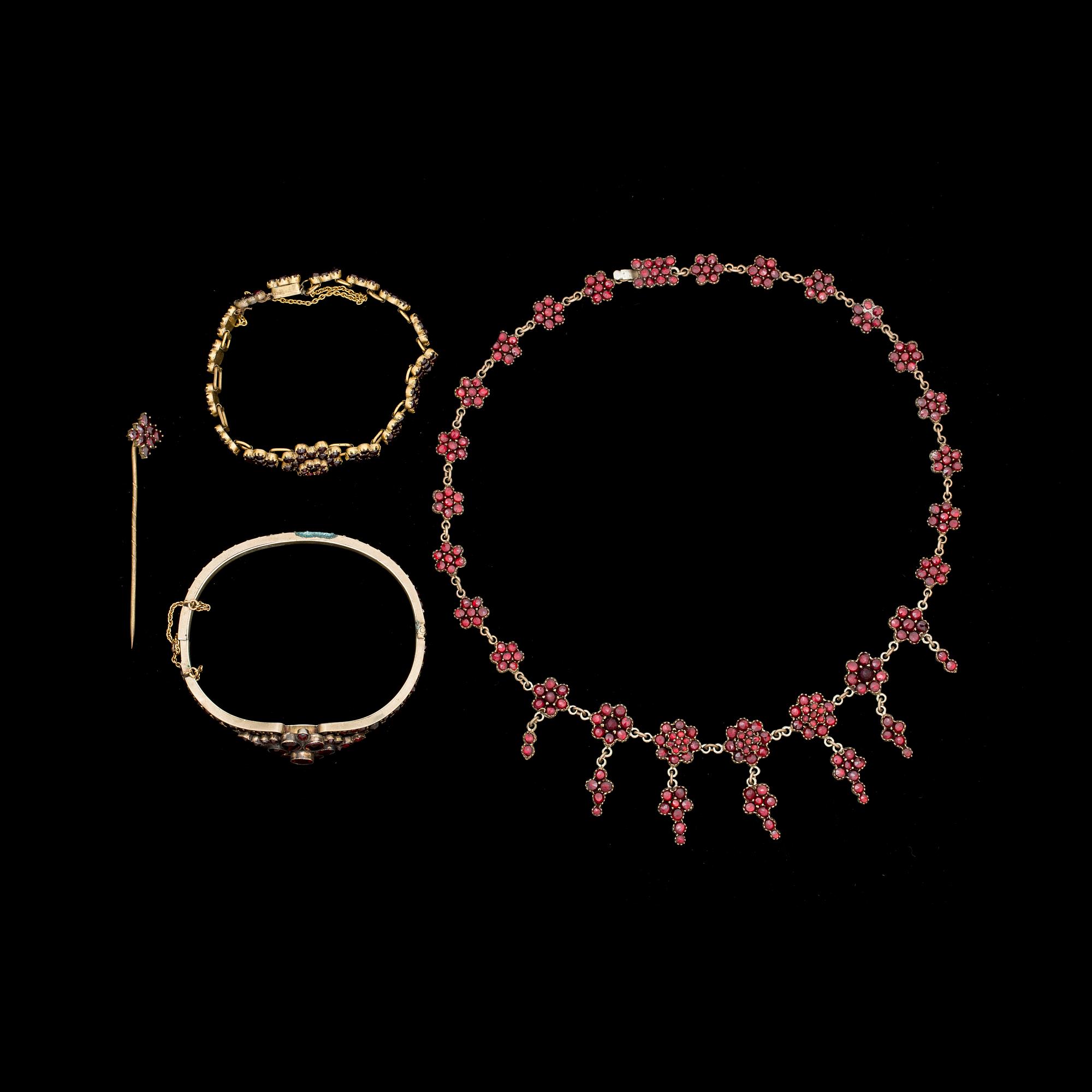 GARNITYR, 4 delar. Gulmetall besatt med granater. Tidigt 1900-tal.