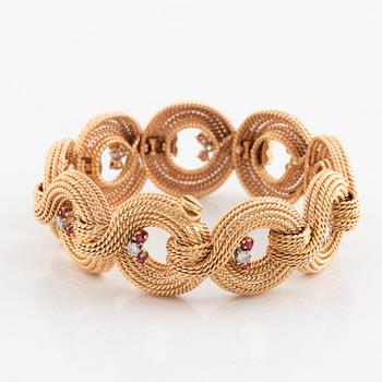 An 18K gold bracelet set with round brilliant-cut diamonds and rubies.