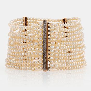 1094. A pearl bracelet with a clasp and dividers in 14K gold and platinum set with rose-cut diamonds.