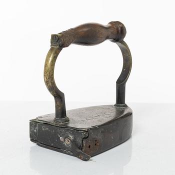 A brass clothes iron, dated 1710.