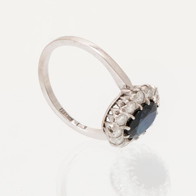 Ring 18K vitguld med oval fasetterad safir samt runda briljantslipade diamanter, Carl Hoff Helsingborg 1973.