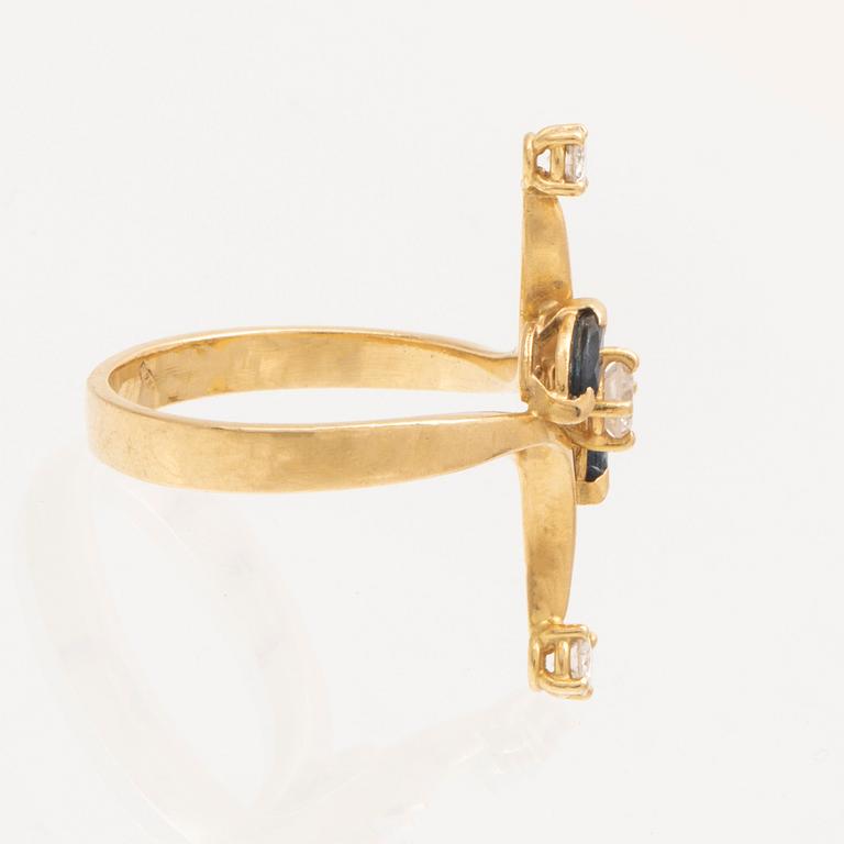 An 18K gold ring with marquise cut sapphires and round brilliant cut diamonds.