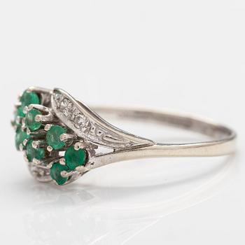 A 14K white gold ring with emeralds and diamonds ca. 0.02 ct in total. Import marked Turun Hopea, Turku 1995.