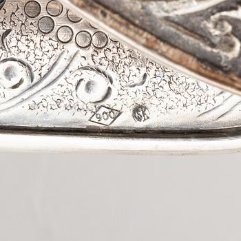 A silver bottle holder with wheels, 20th Century.