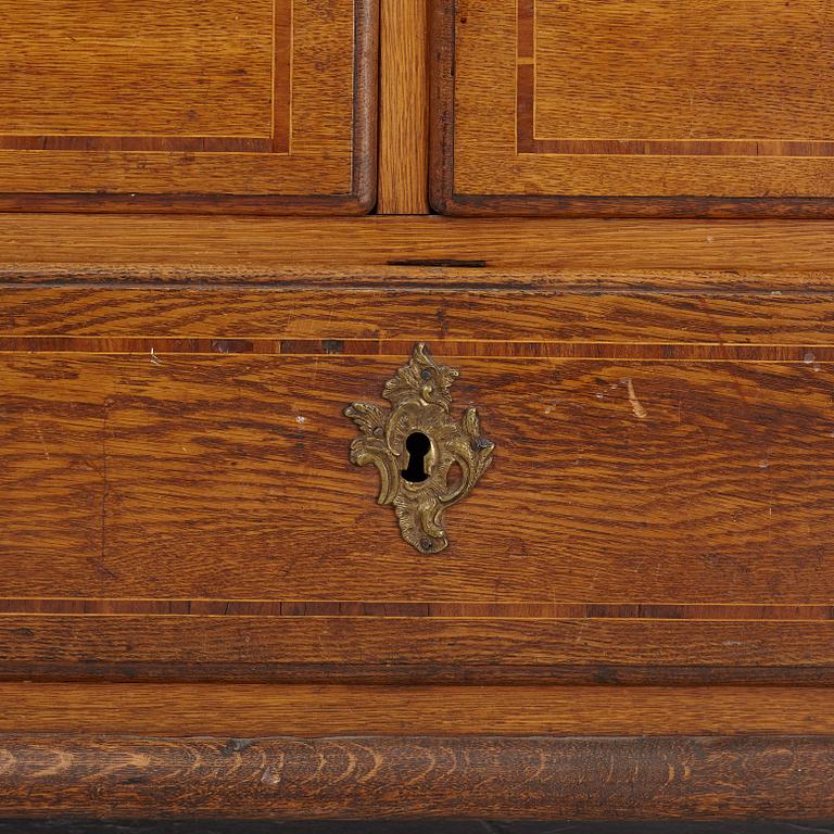 An oak rococo cabinet, mid 18th Century.