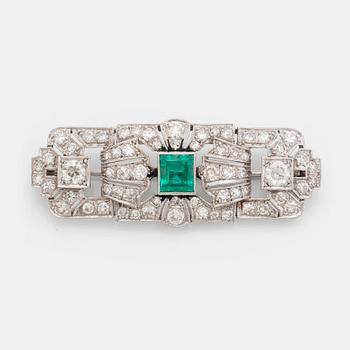 358. A platinum brooch set with a step-cut emerald and old- and eight-cut diamonds.