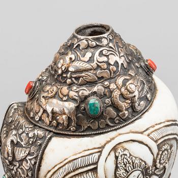 A elaborately decorated ritual Tibetan Conch-shell horn.