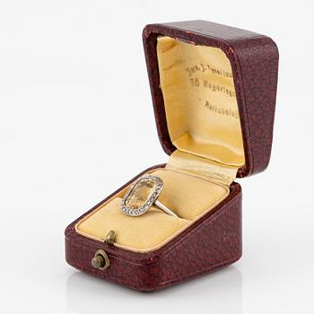 A ring in 18K white gold set with a yellow faceted tourmaline and rose-cut diamonds.