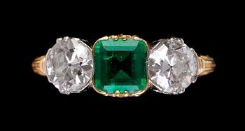 1077. RING, smaragd med två gammalslipade diamanter, vardera ca 0.50 ct. Tidigt 1900-tal.