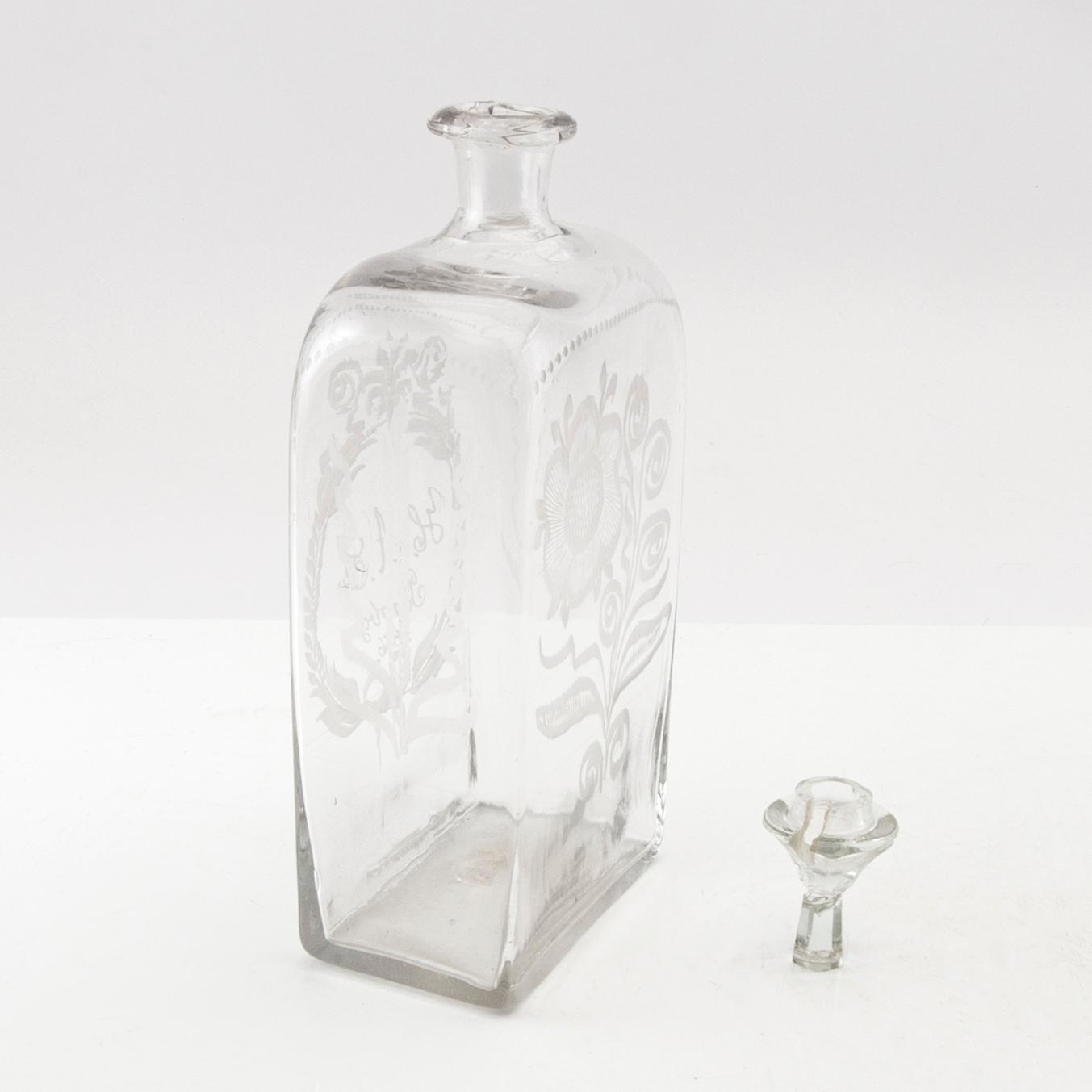 Brännvinsflaska, glas. Daterad Broby 1856.