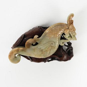 A Chinese nephrite sculpture on a wooden stand, 20th Century.