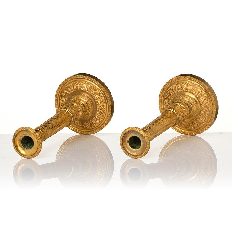 A pair of French Empire ormolu candlesticks, early 19th century.