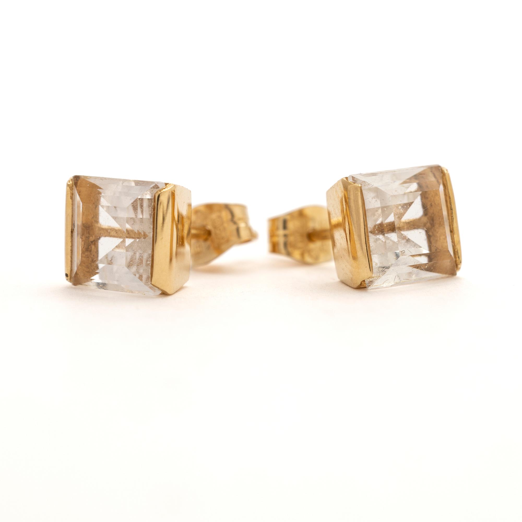 A pair of 18K gold earrings with rock crystal stones.