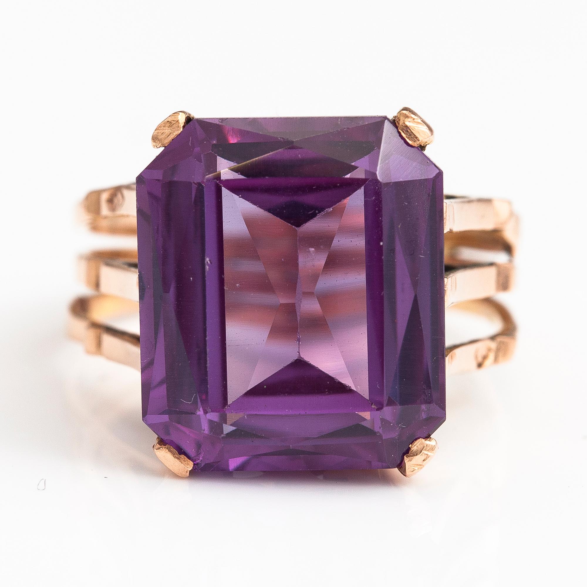 A 9-14K gold ring with a synthetic sapphire.