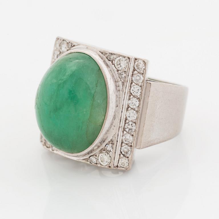 An 18K white gold ring set with a cabochon-cut emerald and round- and eight-cut diamonds.