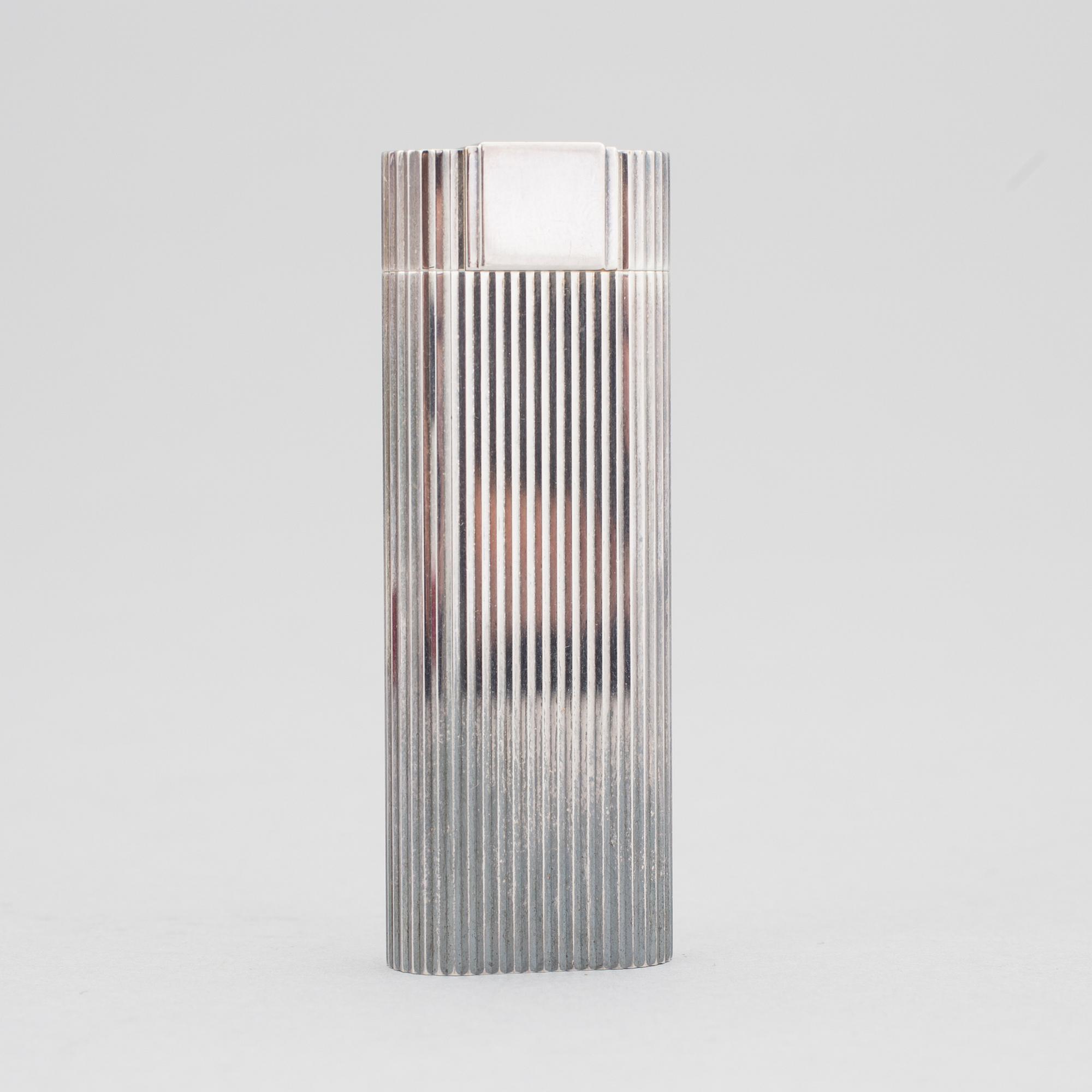 A must de Cartier silver plated cigarette lighter.