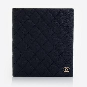 Chanel, a dark blue navy caviar leather notebook.