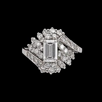 An emerald cut diamond ring, app. 1 ct, smaller brilliant cut diamonds, tot. app. 1 ct.