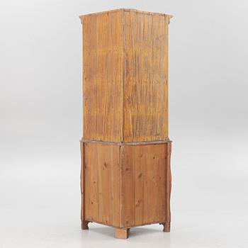 A corner display cabinet, 19th century with a later base.