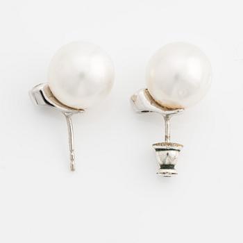 A pair of 18K gold earrings with cultured pearls and round brilliant-cut diamonds.