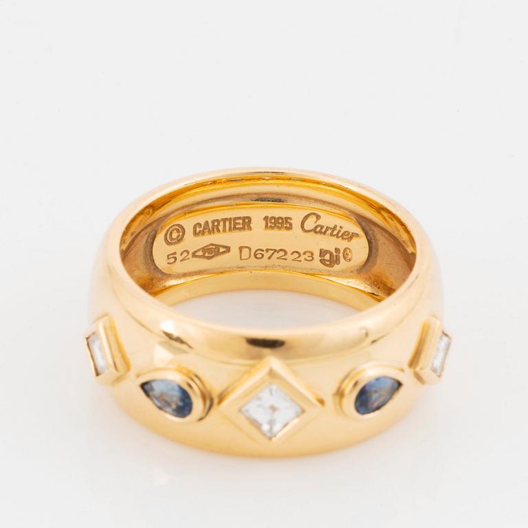 An 18K gold Cartier ring set with step-cut diamonds and faceted sapphires.