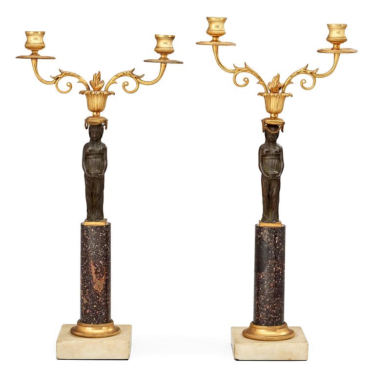 A pair of late Gustavian porphyry and bronze two-light candelabra.