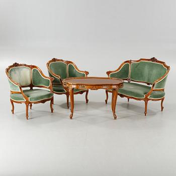 A rococo style sofa, two lounge chairs and a table, around the year 1900 and first half of the 20th century.