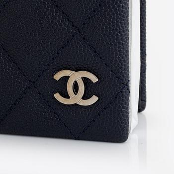 Chanel, a dark blue navy caviar leather notebook.