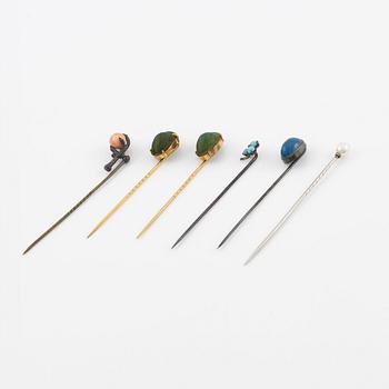 Six brooch pins in various designs and materials.