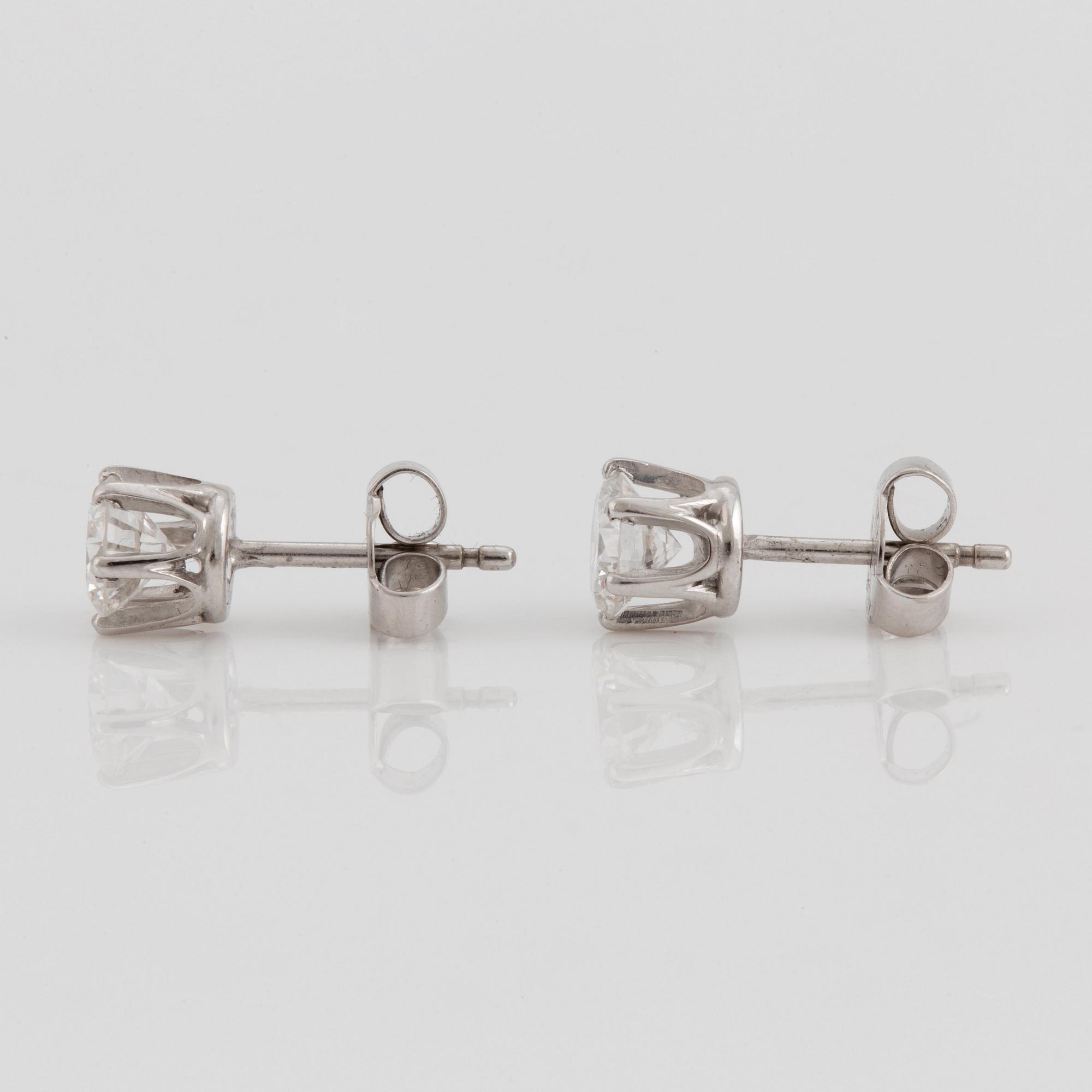 A pair of brilliant cut diamond earrings.
