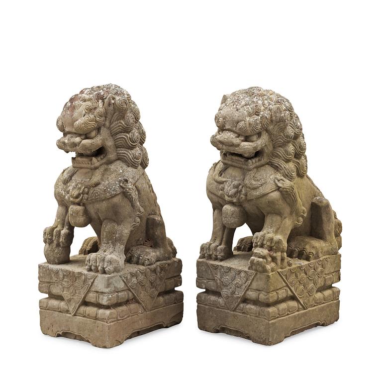 A pair of stone figures of Buddhist Lions on stands, late Qing dynasty / early 20th century..